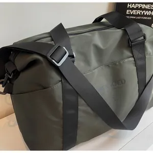 Close-up of olive green duffel bag showing durable black nylon strap and textured fabric