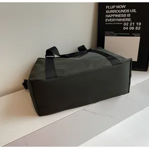 Bottom view of large dark green travel duffel bag with black durable straps
