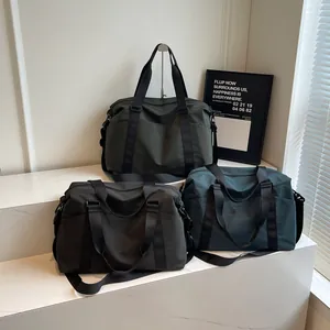 Large capacity travel duffel bags in green, black, and teal on white stairs.