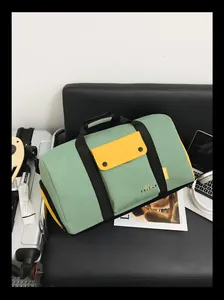 Vue détaillée d'un grand sac de voyage de sport vert et jaune posé sur une chaise