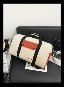 Sac de sport crème et orange avec sangles noires dans un décor de voyage décontracté