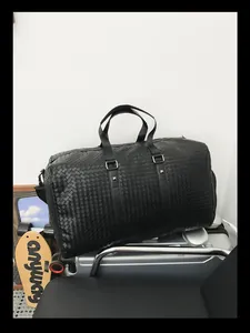 Grand sac de voyage d'affaires avec texture en cuir tressé noir et poignées robustes