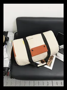 Grand sac de voyage en toile crème pour le sport et les voyages sur un siège noir