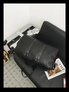 Sac de voyage tissé noir haut de gamme avec un intérieur spacieux dans un décor chic.