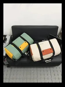 Deux grands sacs de sport vert et blanc sur un canapé pour le fitness et les voyages.