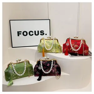 Vista detallada de bolsos bordados de estilo chino con asas de perlas y borlas