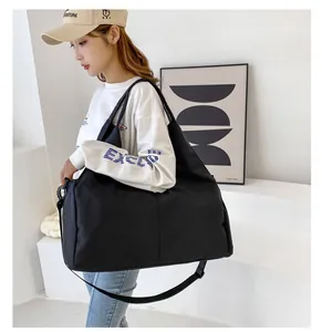 Große schwarze Oxford-Reisetasche, die von einem Model in minimalistischer Umgebung getragen wird