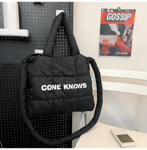 Détail d'un sac cabas tendance en nylon matelassé noir avec l'imprimé 'CONE KNOWS' en gros plan