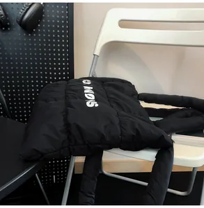 Gros plan du sac cabas noir matelassé avec imprimé de lettres blanches SNOW et texture