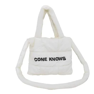Sac cabas matelassé blanc avec texte CONE KNOWS et bandoulière rembourrée.