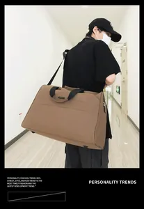 Große braune Reisetasche am Modell in einem Flur, perfekt für Geschäftsreisen