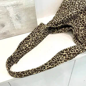 Close-up detail of the strap and leopard print cotton fabric on a stylish retro tote bag