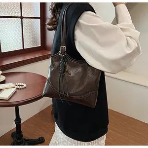 Vintage dark brown faux leather shoulder tote bag featuring a decorative woven tassel charm