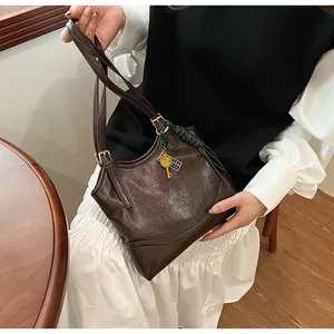Detailed view of vintage dark brown faux leather tote bag featuring elegant key charm