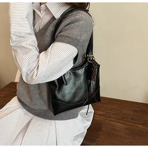 Close-up view of a model wearing a vintage black minimalist shoulder tote bag for women.