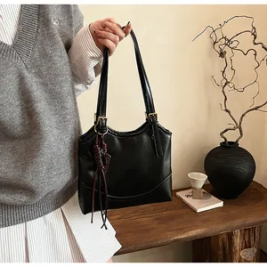 Elegant lifestyle view of a vintage black underarm bag held by a model in a cozy room.