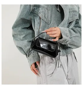 Elegante mini borsa baguette nera lucida con tracolla sottile tenuta dalla modella