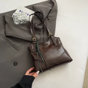 Vintage coffee brown tote bag detail on grey blazer backdrop