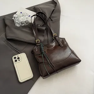 Vintage dark brown faux leather tote bag detail with golden adjustable buckles.