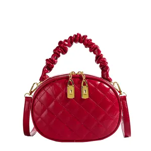 Elegant red quilted handbag featuring a unique gathered scrunchie handle design detail