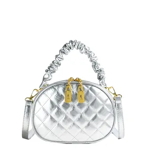 Detailed view of a silver quilted handbag with a metallic finish and ruffled handle