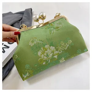 Detalle de bolso bordado estilo chino retro con motivo floral y cierre de perlas