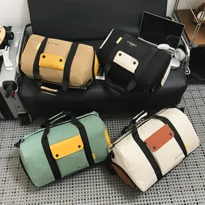 Quatre sacs de voyage et de sport grande capacité en diverses couleurs sur un canapé noir
