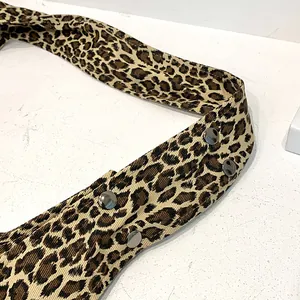 Close-up of leopard print cotton tote bag strap with decorative silver metal rivets