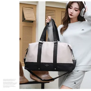 Large stylish two-tone travel duffel bag held by a model in a casual lifestyle scene