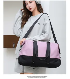 Model carrying large capacity pink and black travel duffel bag for fitness and sport