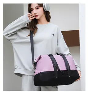 Asian female model carrying a pink and black large-capacity stylish travel duffel bag.
