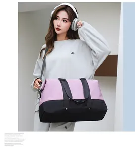 Large capacity lavender and black travel duffel bag held by a model in a casual setting