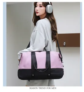 Close-up detail of the large capacity pink and black duffel bag carried by a model