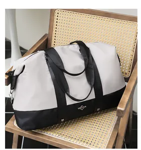 Stylish large capacity two-tone travel duffle bag displayed on a wooden chair.