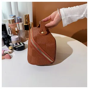 Close-up of portable brown checkered square makeup bag with handle