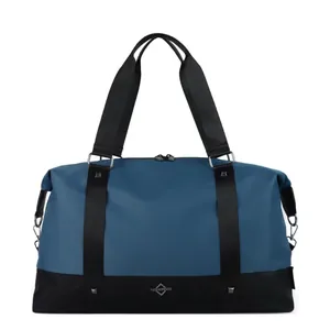 Front view detail showing a large blue and black travel duffel bag with sturdy handles