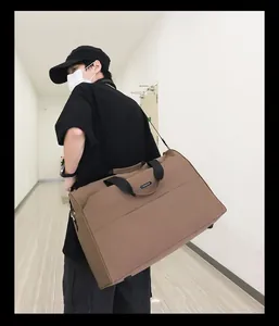 Seitenansicht einer großen braunen Reisetasche mit schwarzen Riemen, die ein Model trägt.