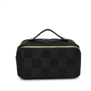 Detailed view of the black woven checkered pattern and gold hardware on handbag