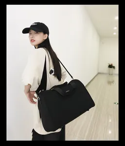 Detailansicht der minimalistischen schwarzen Reisetasche getragen von einem weiblichen Model