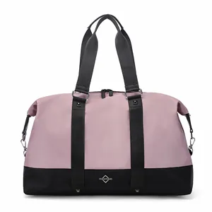Detail of pink and black travel duffel bag with silver studs and fashion logo plate