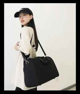 Frau trägt eine große schwarze Reisetasche über der Schulter für Business oder Gym