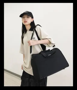 Große schwarze Reisetasche, getragen von einem Modell, ideal für Reisen oder Fitness