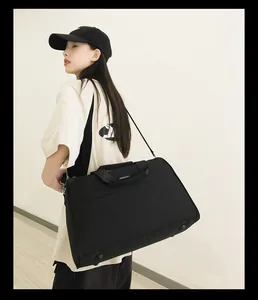 Asiatisches Model trägt eine große schwarze Reisetasche für Business und Sport