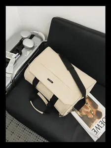 Große beige Reisetasche auf einem schwarzen Stuhl mit Gepäck und Zeitschriften-Requisiten