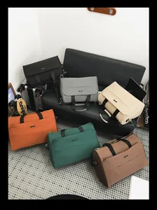 Große Reisetaschen in verschiedenen Farben auf einem modernen schwarzen Sofa präsentiert