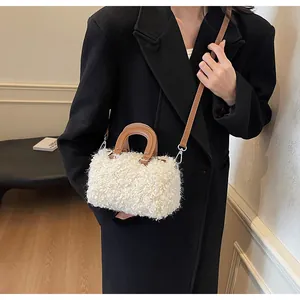 Close-up view of a stylish white fuzzy plush box handbag with brown leather-like straps.