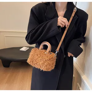 Detailed macro view of a fuzzy brown plush box handbag with leather handles on model