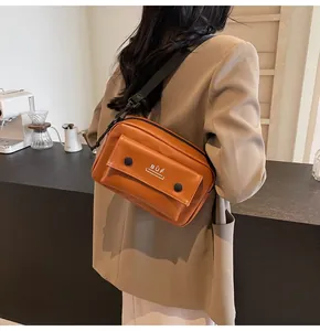Vista detallada de un modelo que lleva un bolso bandolera marrón vintage por detrás