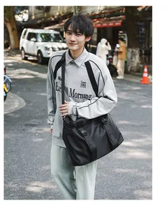 Große schwarze Reisetasche, getragen von einem Model in einer natürlichen Straßenszene