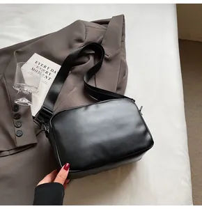 Primer plano de bolso bandolera negro minimalista en ecocuero con correa ajustable